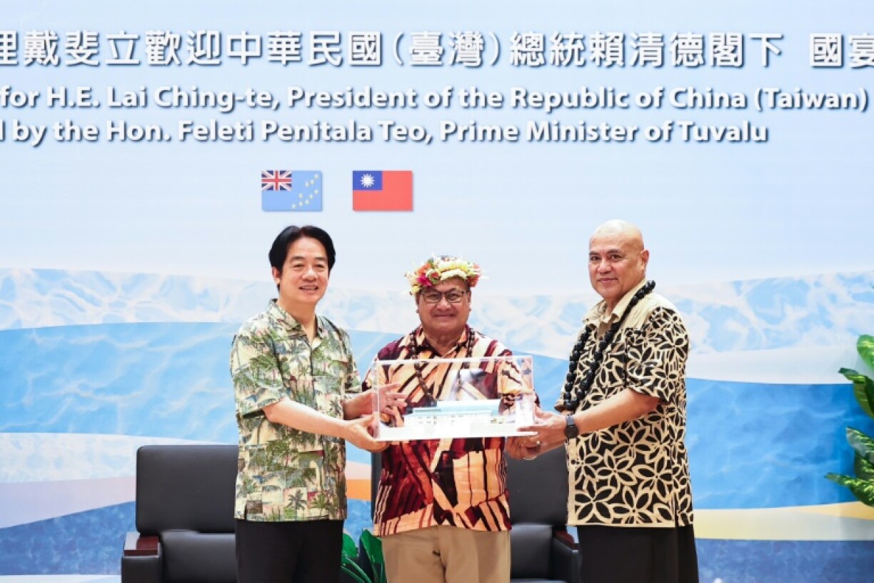Taiwan President Lai Ching-te (L) receiving a souvenir from Tuvalu Prime Minister Feleti Teo (R)