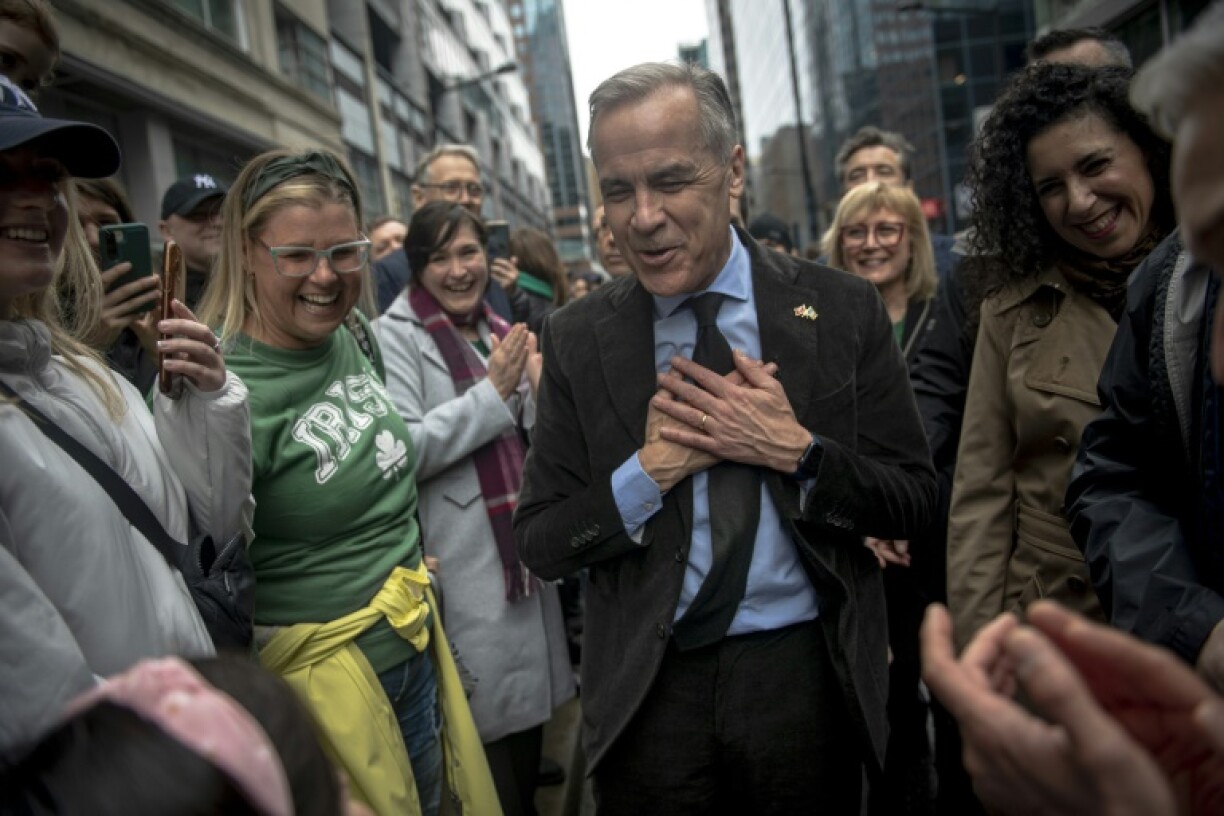 Canadian Prime Minister Mark Carney (C) is greeted by young supporter at Montreal's Saint Patrick's Day Parade in Montreal on March 16