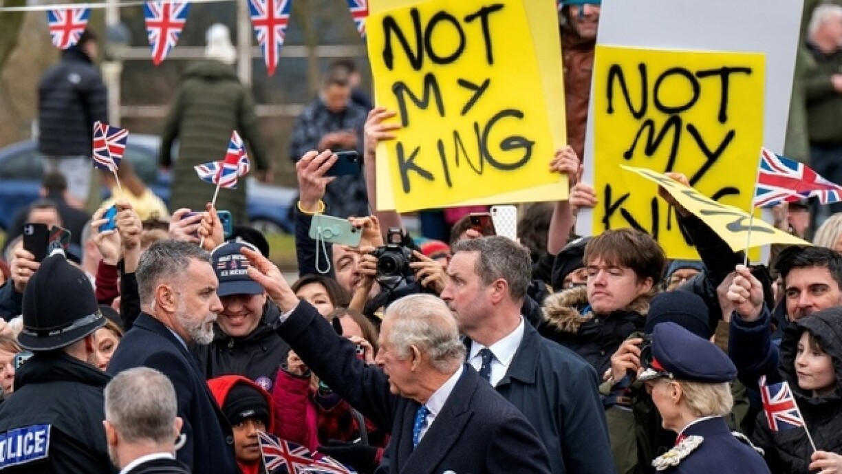 Le roi Charles III (c) accueilli par une poignée de militants anti-monarchie, lors d'un déplacement à Milton Keynes, le 16 février 2023 au nord de Londres