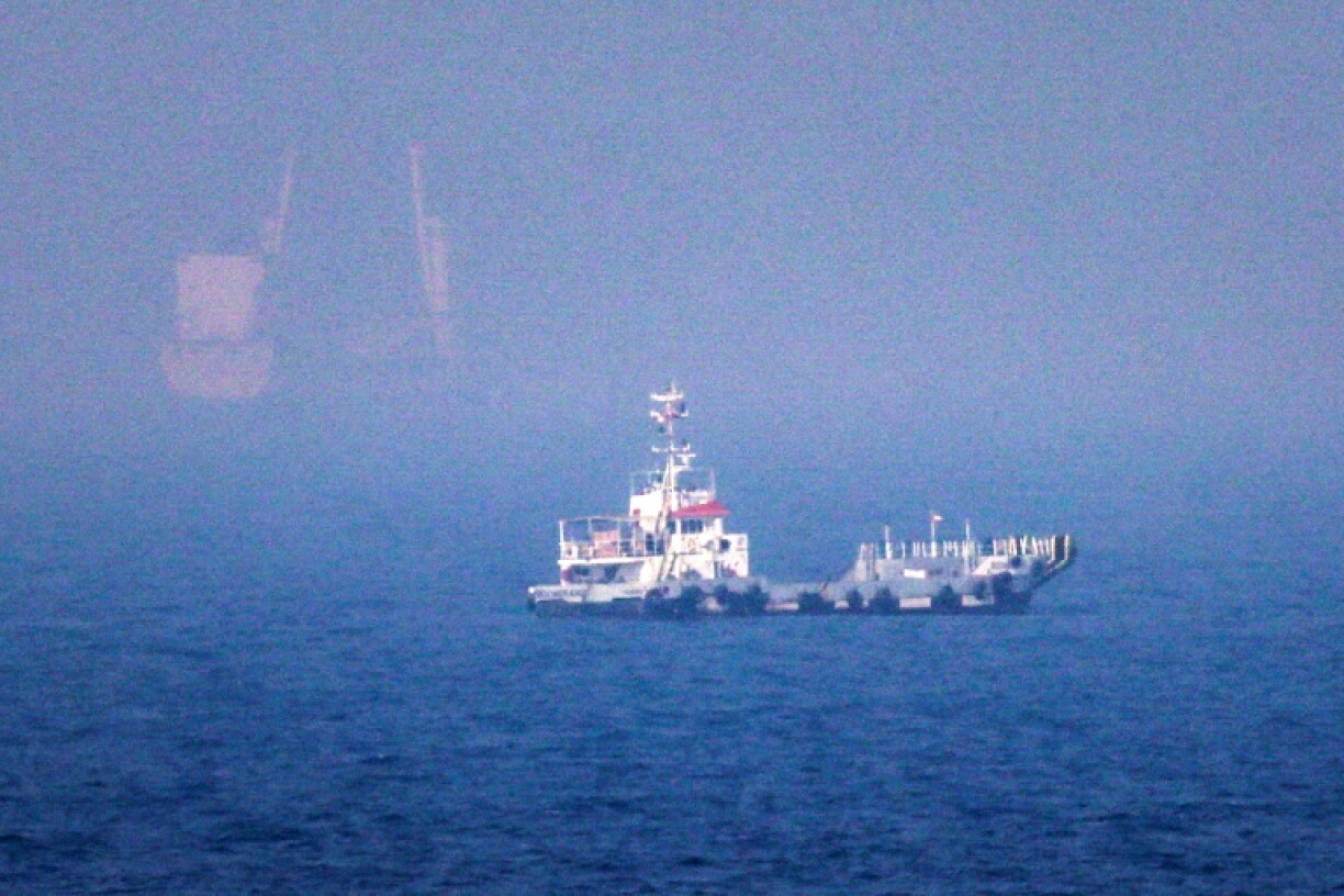 Des navires naviguent près du détroit d'Ormuz, au large de la côte orientale des Émirats arabes unis, à Khor Fakkan, le 13 juillet 2026