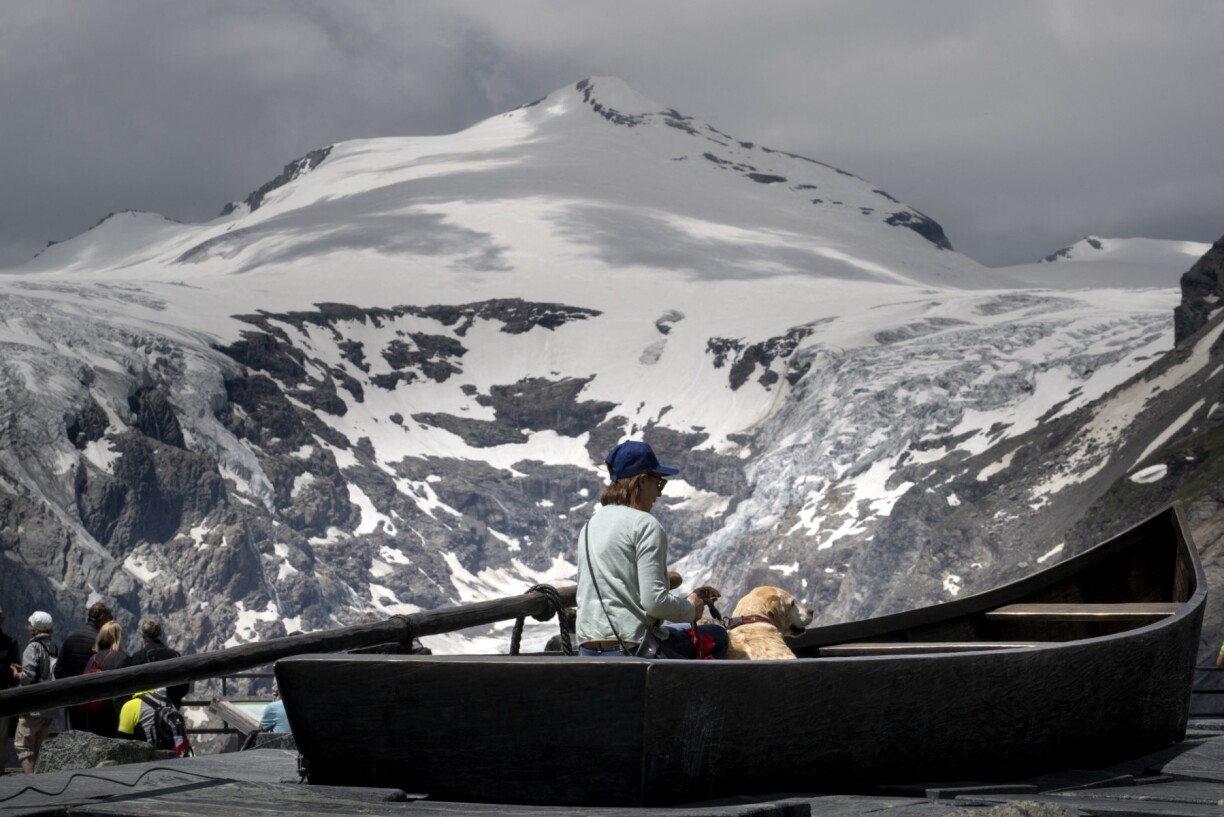 Un touriste regarde la fonte du glacier Pasterze en Autriche.