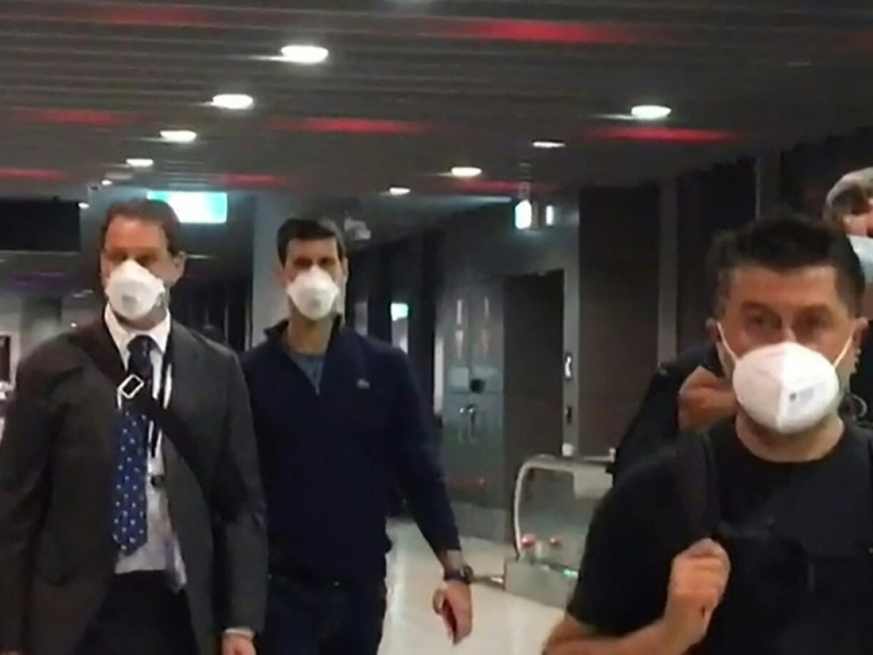 Novak Djokovic was pictured at Melbourne Airport on his way out of the country (second from left).