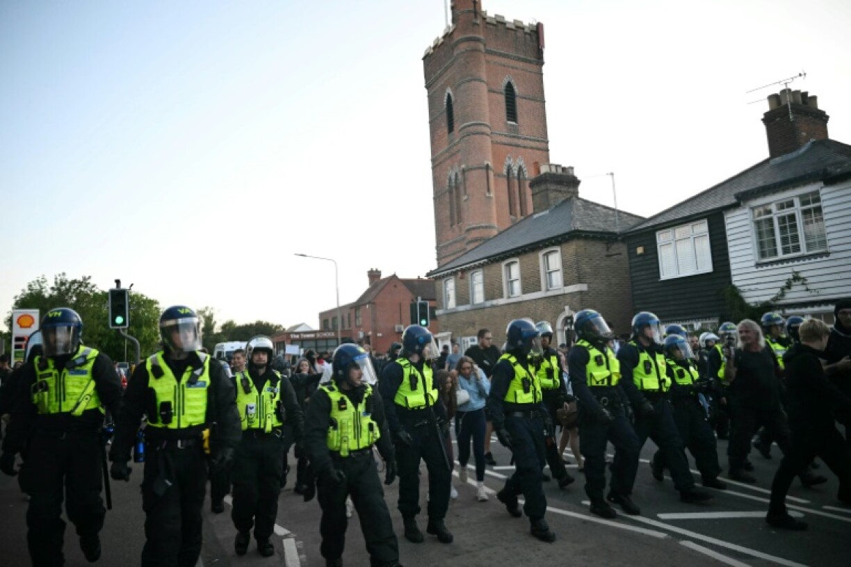 Riot police follow a march into the town centre of Epping, northeast of London, on July 20, 2025