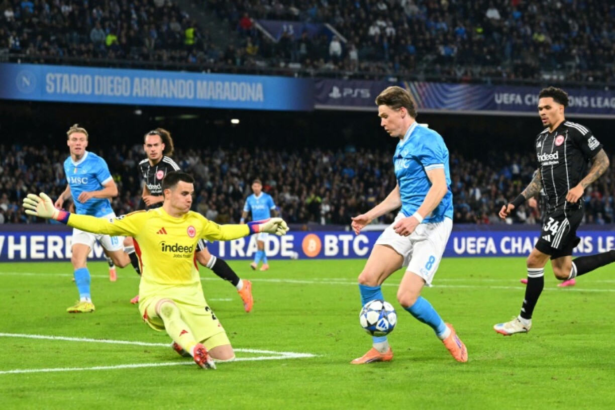 Napoli's Scottish midfielder #08 Scott McTominay tries to score against Frankfurt's German goalkeeper #23 Michael Zetterer during the UEFA Champions League - league phase day 4 football match between Napoli and Eintracht Frankfurt at the Diego Armando Maradona stadium in Naples on November 4, 2025
