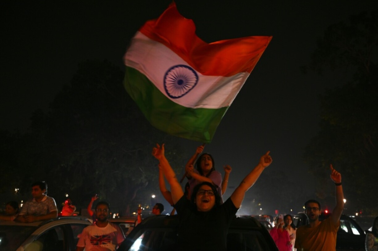 Fans wave flags as they celebrate India's victory in New Delhi