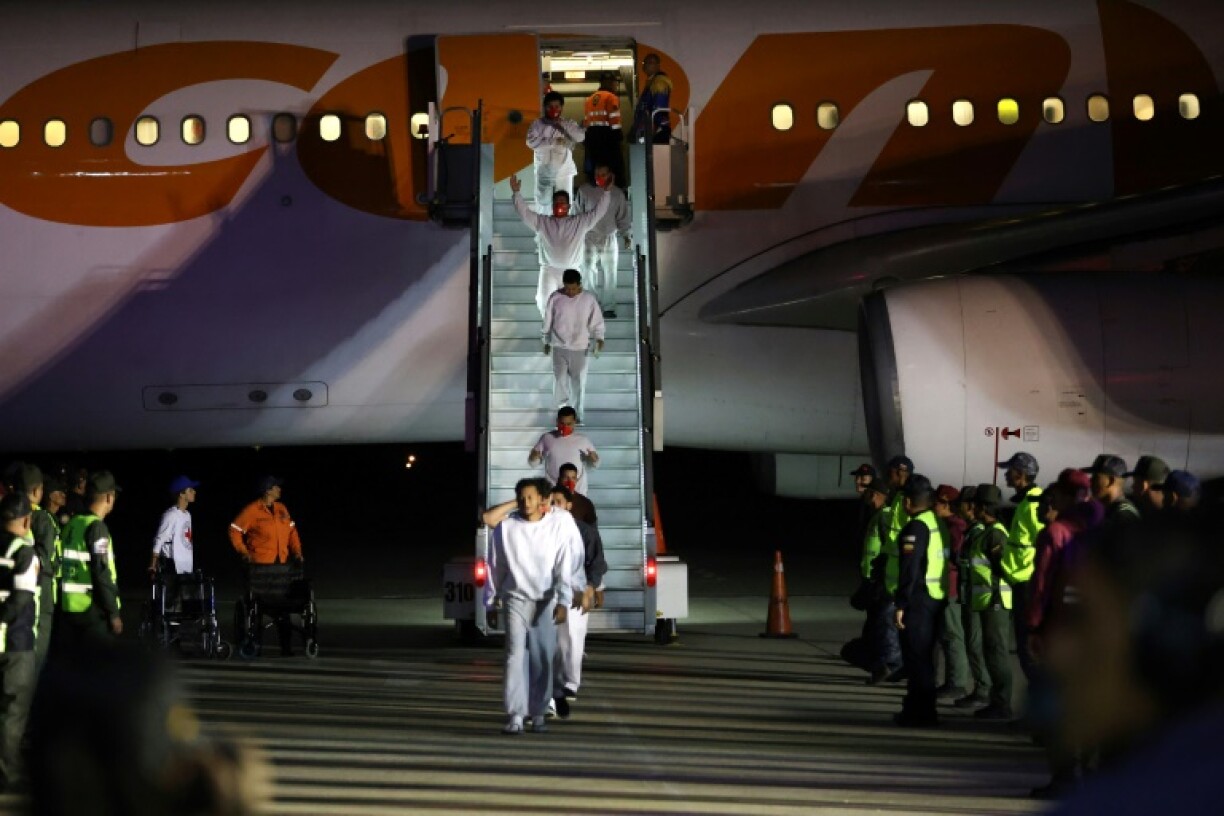 Venezuelan migrants deported from US Naval Station Guantanamo Bay walk down from the Venezuelan Conviasa Airlines plane as they arrive at Simon Bolivar International Airport in Maiquetia, Venezuela on February 20, 2025