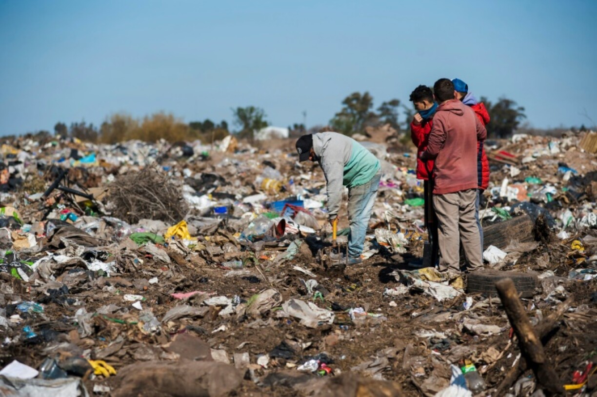 Des hommes fouillent dans une décharge à la recherche de billets de 100 dollars, le 20 juillet 2022 à Las Parejas, en Argentine
