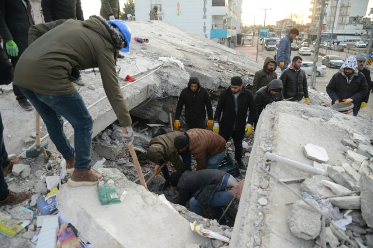 Des habitants et des sauveteurs recherchent des survivants dans les décombres d'immeubles effondrés, deux jours après un puissant séisme, le 8 février 2023 à Adiyaman, en Turquie.