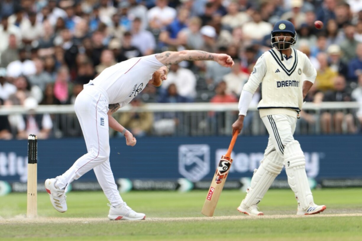 England captain Ben Stokes (L) bowls in the fourth Test at Old Trafford as India's Ravindra Jadeja (R) looks on