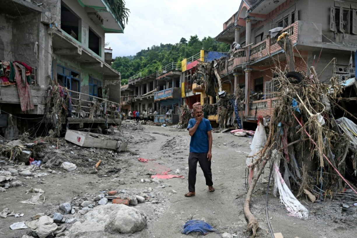 Un habitant passe devant des maisons endommagées par des crues soudaines à Devighat, dans le district de Nuwakot, le 31 août 2026 au Népal