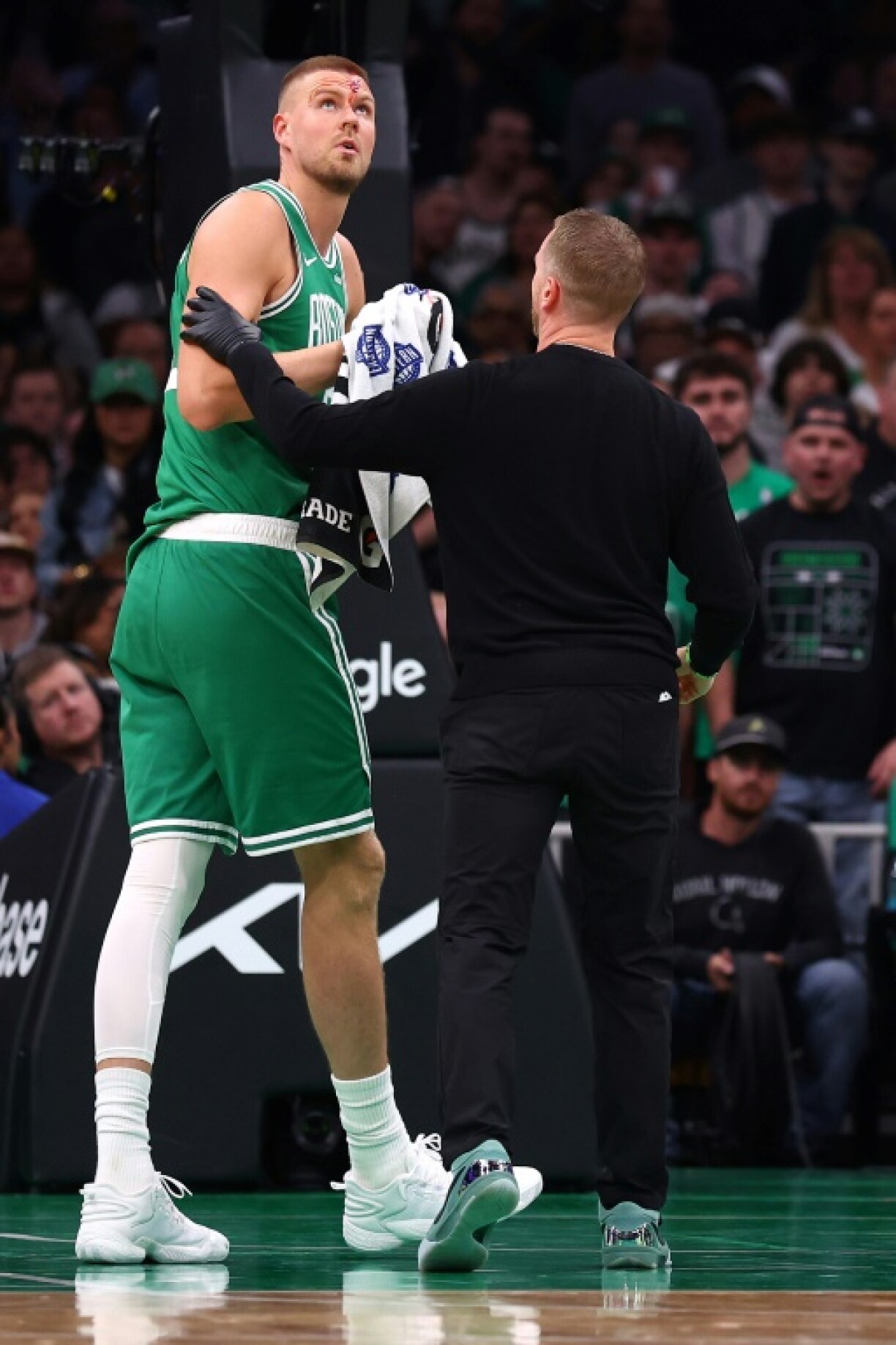 Boston's Kristaps Porzingis walks to the locker room after suffering a bloody cut on his forehead in the third quarter of the Celtics' NBA playoff victory over Orlando