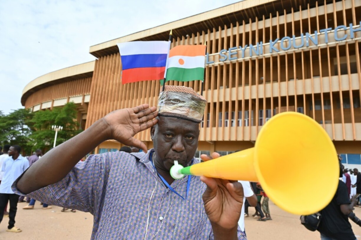 Un partisan des militaires qui ont pris le pouvoir au Niger, coiffé d'un chapeau orné des drapeaux russe et nigérian, manifeste à Niamey le 6 août 2023