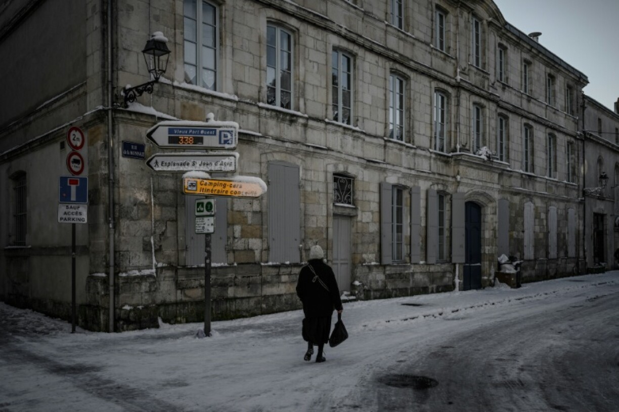 Une femme marche dans une rue après des chutes de neige, le 6 janvier 2026 à La Rochelle en Charente-Maritime