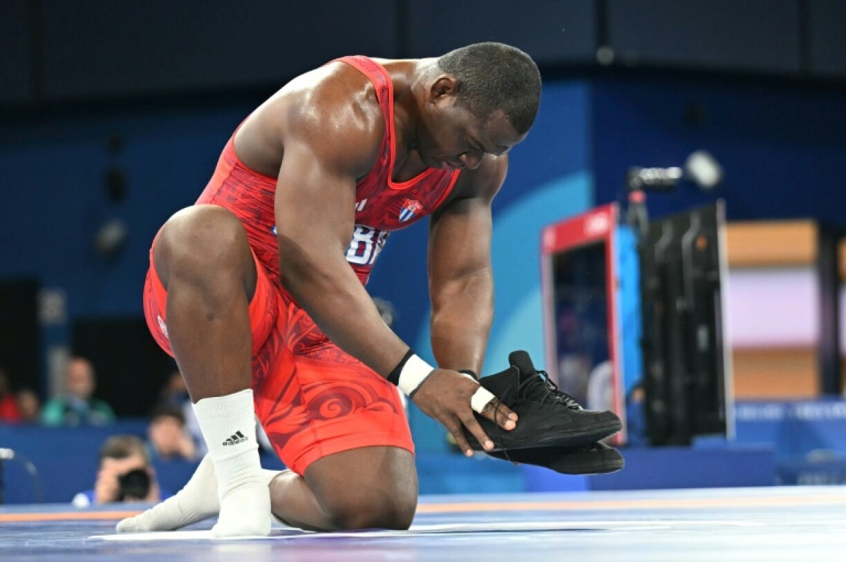 Mijain Lopez signals his retirement by leaving his shoes on the mat after winning gold in Paris