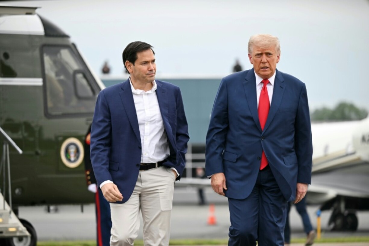 US President Donald Trump (R), seen here with Secretary of State Marco Rubio, has slapped a travel ban on a dozen countries