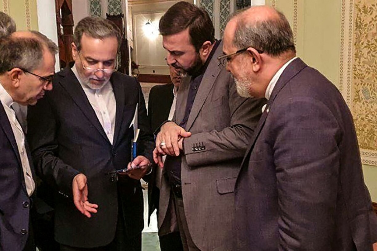 This picture provided by Iranian news website Khabar Online shows Iranian Foreign Minister Abbas Araghchi (2nd-L) speaking with members of his delegation during a break in his meetings in Oman.