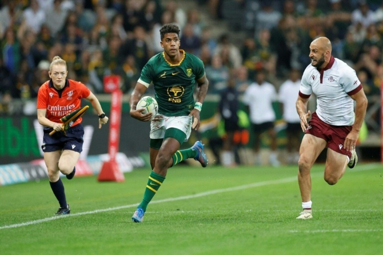 South Africa centre Canan Moodie (L) runs with the ball against Georgia in Mbombela