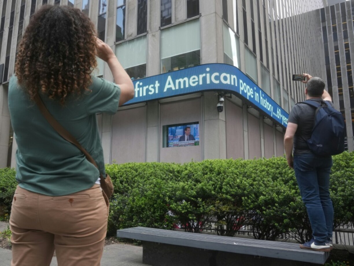 People take photos of the display on FOX headquarters in New York on May 8, 2025, showing reaction to newly elected Pope Leo XIV, Robert Prevost