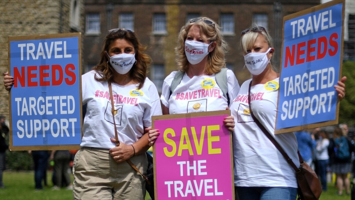 Representatives from the travel industry demonstrate during a 'Travel Day of Action' outside the Houses of Parliament in central London on June 23, 2021, calling on the UK Government to support a safe return of international travel in time for the peak summer period.