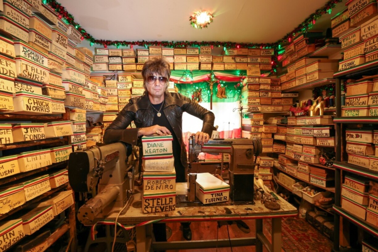 Shoemaker Chris Francis poses with boxes containing the carved molds of celebrities' feet made by Pasquale Di Fabrizio, who made shoes for Hollywood stars for decades