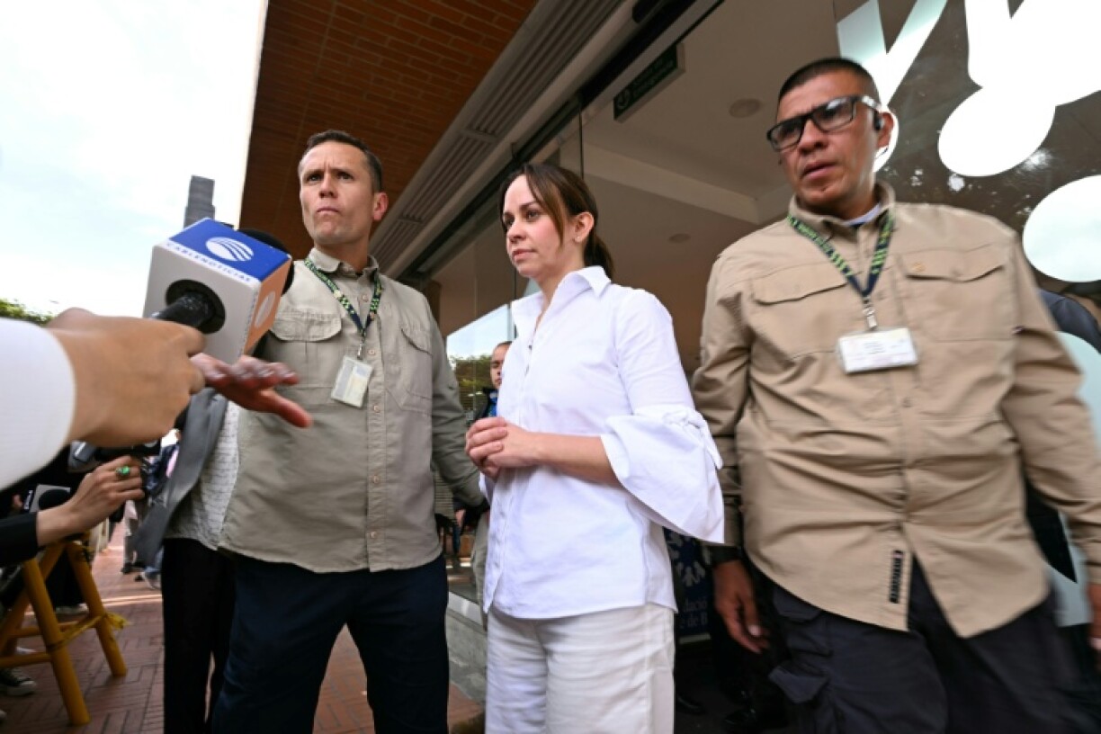 Wife of the Colombian presidential candidate Miguel Uribe, Claudia Tarazona (C), reacts before speaking to the media outside the Fundacion Santa Fe clinic in Bogota on June 16, 2025.