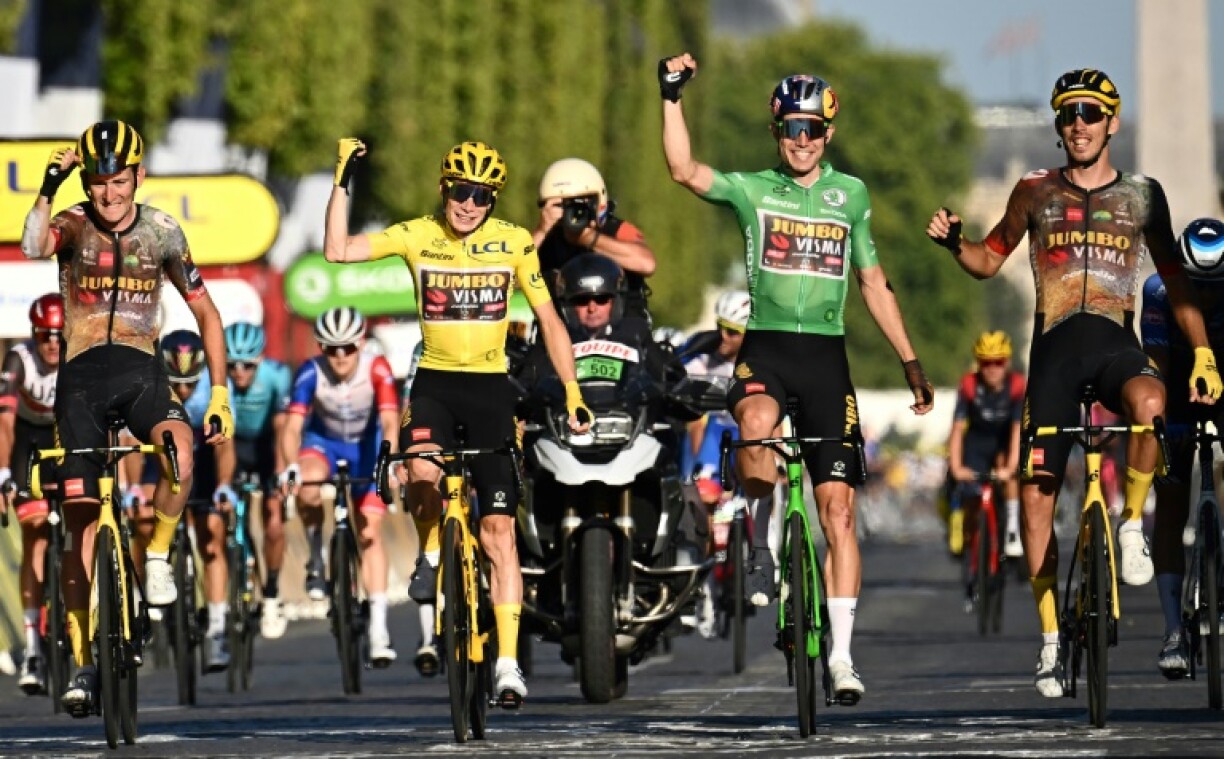 Le coureur belge de la Jumbo-Visma, Tiesj Benoot (tout à gauche) lors de l'arrivée du Tour de France sur les Champs Elysées aux côtés du maillot jaune Jonas Vingegaard et du maillot vert Wout van Aert, le 24 juillet 2022 à Paris