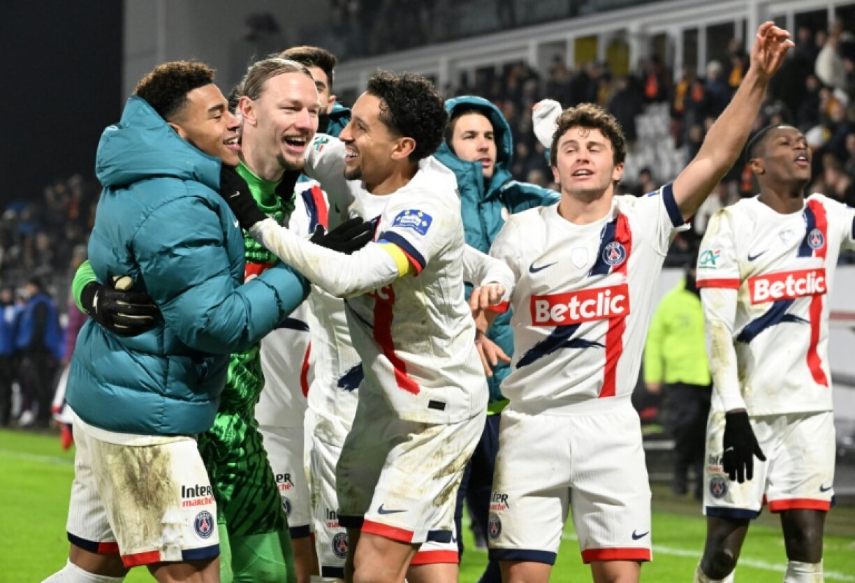 PSG players celebrate with goalkeeper Matvey Safonov after he helped them beat Lens on penalties in the French Cup on Sunday