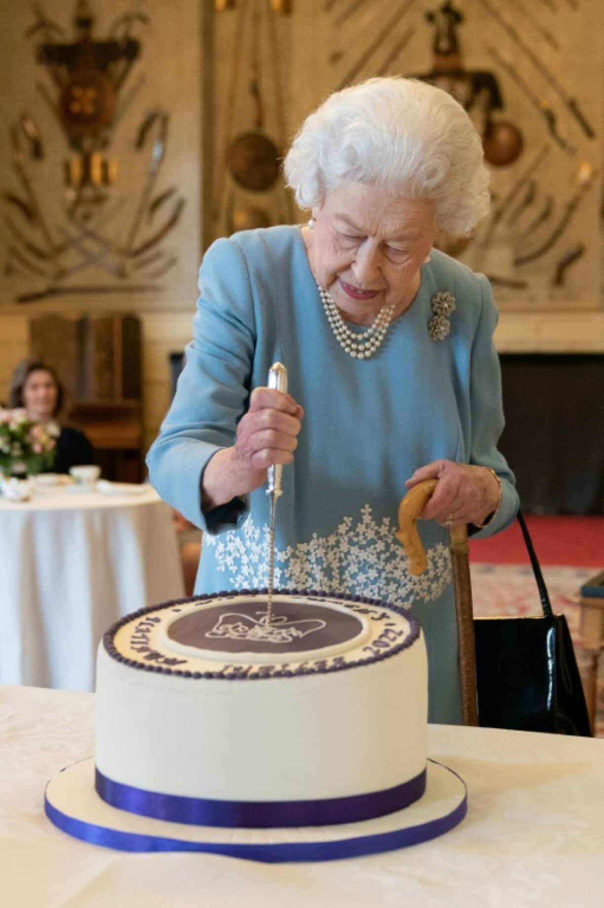 La reine d'Angleterre Elizabeth II découpe un gateau pour son jubilé de platine le 5 février 2022 dans sa résidence Sandringham House