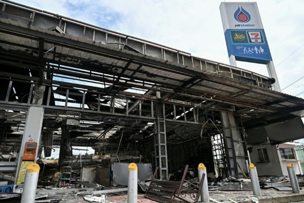 Damage from a fire caused by Cambodian artillery at a 7-11 convenience store is seen at a gas station in the Thai border province of Sisaket