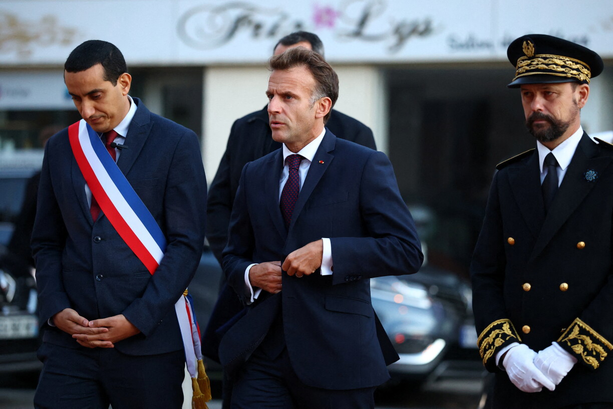 De Buergermeeschter vun Trappes Ali Rabeh an de franséische President Emmanuel Macron op der Onglécksplaz.