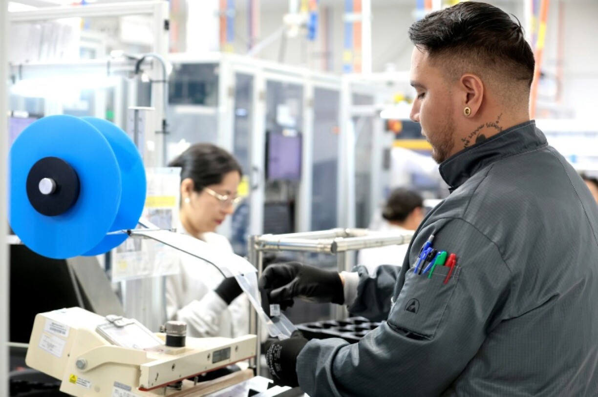 Workers assemble electronic car keys at a manufacturing plant in Mexico
