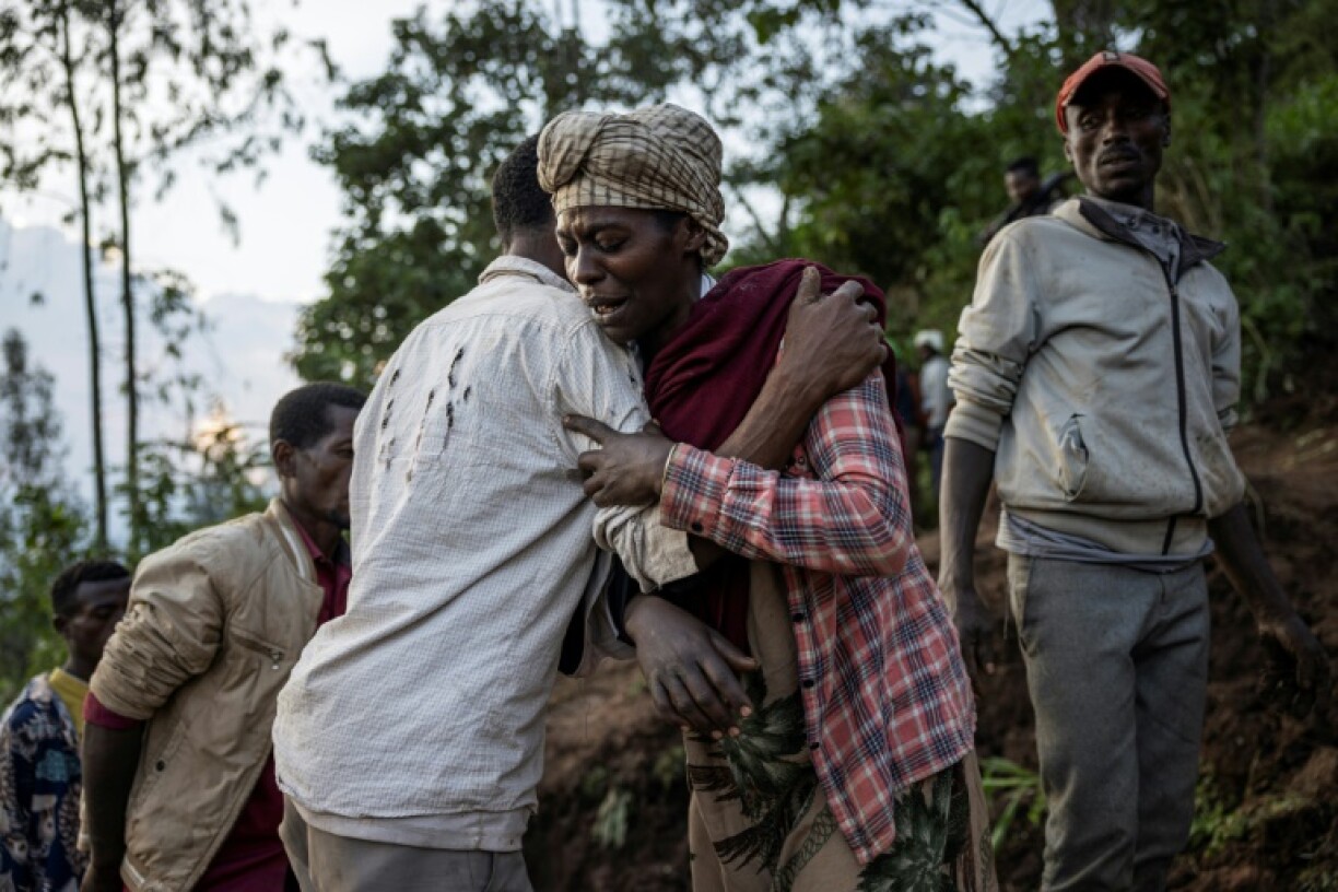 Une femme est reconfortée par un habitant, le 24 juillet 2024, à Kencho Shacha Gozdi, dans le sud de l'Ethiopie, théâtre d'un glissement de terrain très meurtrier
