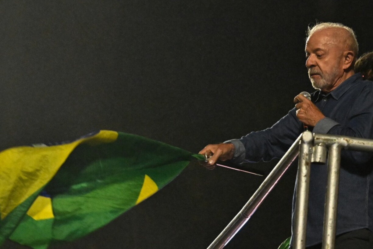 Le président de gauche Lula brandit un drapeau lors d'un discours de victoire au second tour de la présidentielle devant ses partisans à Sao Paulo, dans le sud-est du Brésil, le 25 octobre 2026