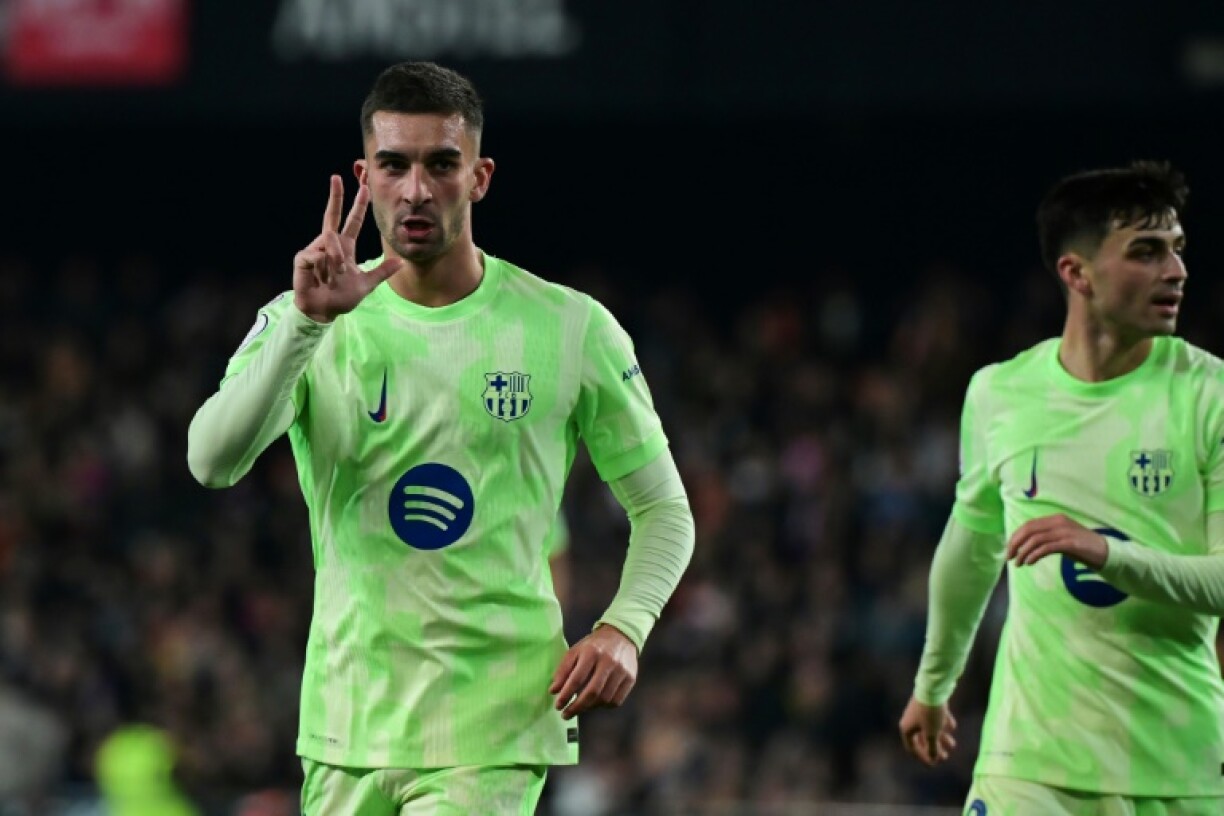 Barcelona's Spanish forward Ferran Torres holds up three fingers after scoring his third goal against Valencia
