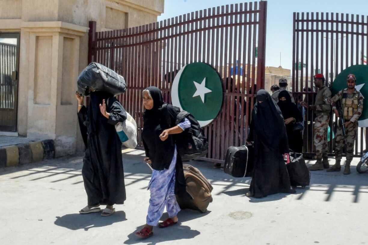 Pakistani pilgrims evacuated from Iran walk across the Pakistan-Iran border at Taftan, in Balochistan province