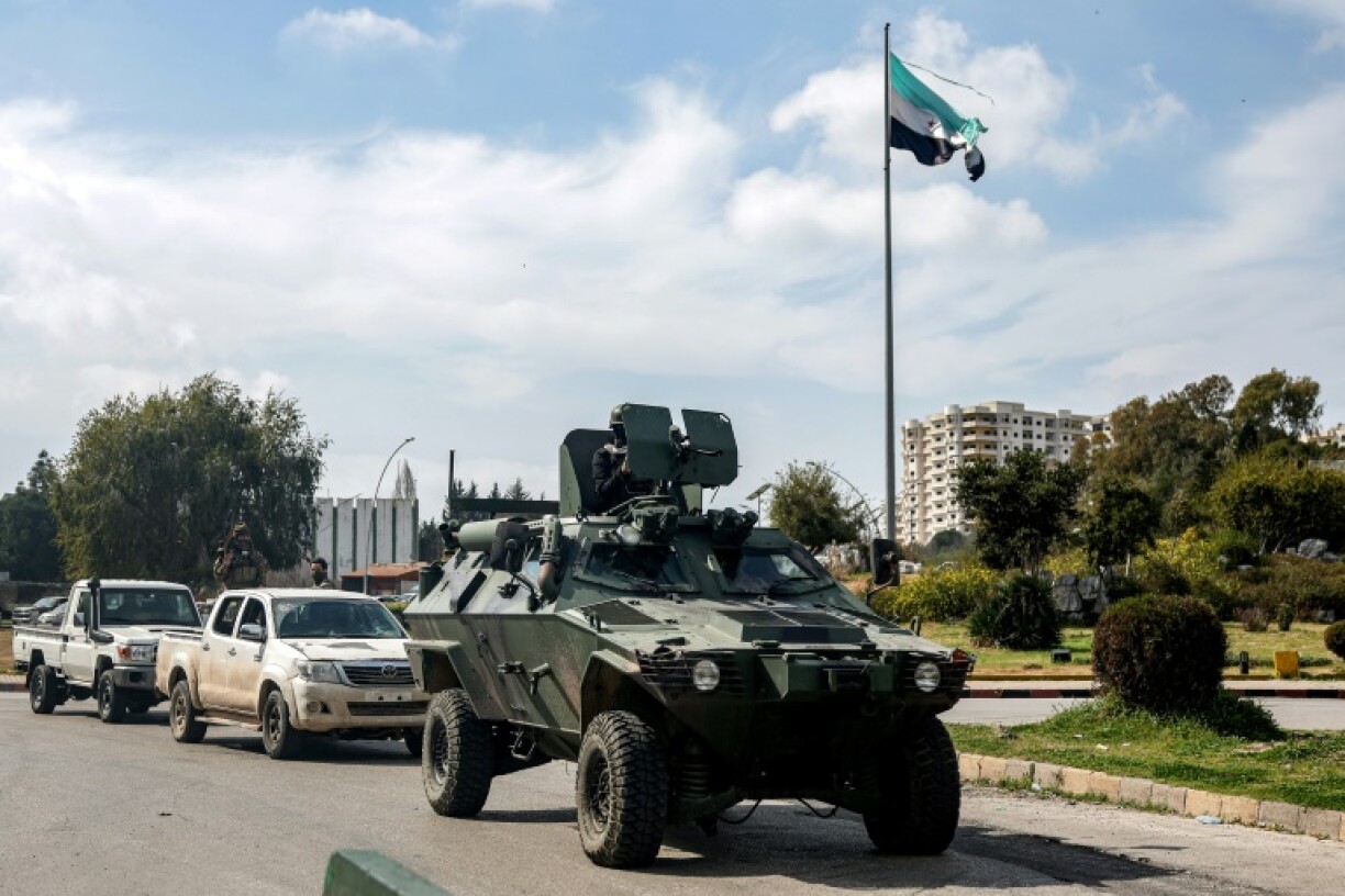 An armoured vehicle used by security forces loyal to the interim Syrian government moves through Latakia