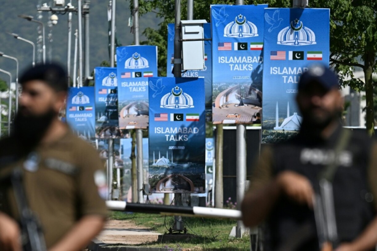 Des membres des forces de sécurité montent la garde le long d'une route temporairement fermée en prévision des pourparlers de paix américano-iranien, le 20 avril 2026 à Islamabad, au Pakistan