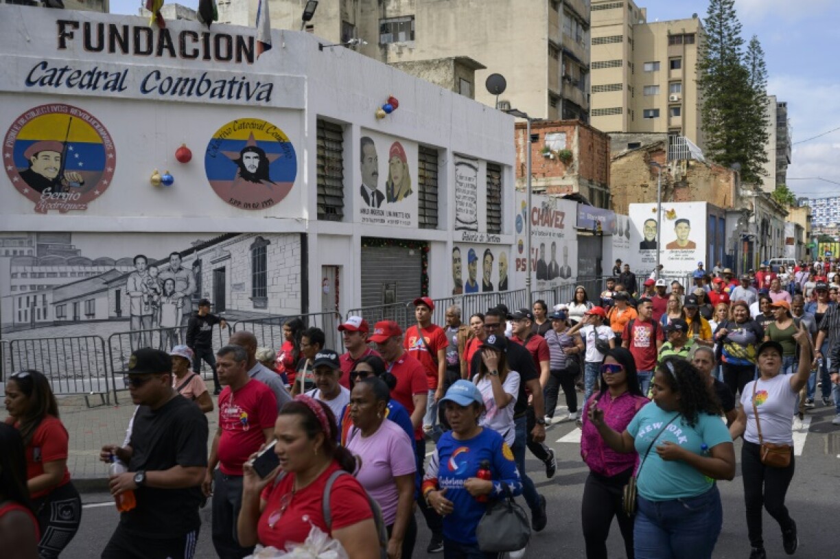 Supporters of President Nicolas Maduro walk past the headquarters of the 'Catedral Combativa,' a pro-government group known as a 'colectivo,' in downtown Caracas