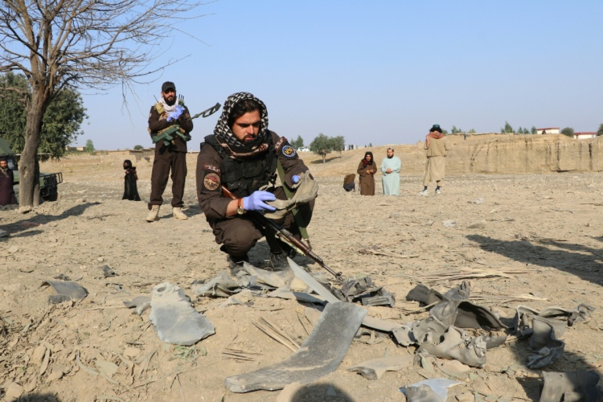 Taliban security personnel inspect a site hit in Pakistan's air raid