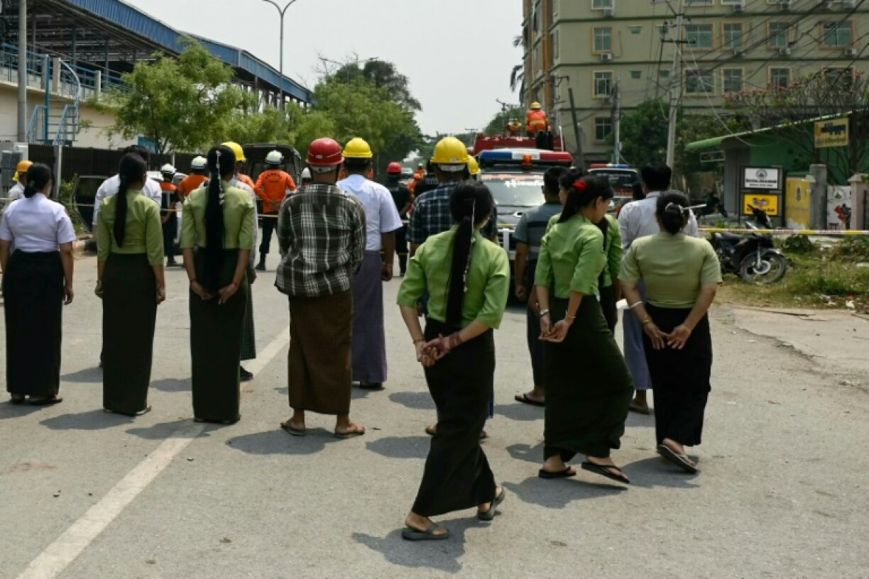 People observe a minute of silence near the Sky Villa condominium, one of the sites most affected by the March 28 earthquake in Myanmar