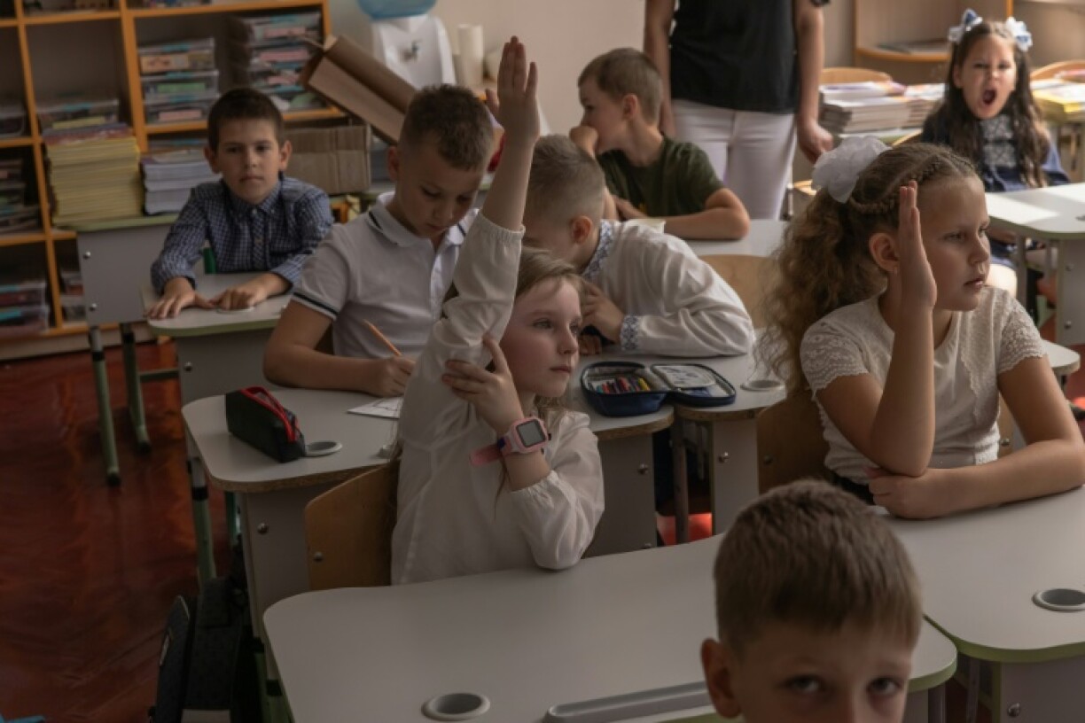 Nadiya Mikhailyuk (g) avec les élèves de sa classe le jour de la rentrée, le 1er septembre 2023 à Irpin, près de Kiev, en Ukraine