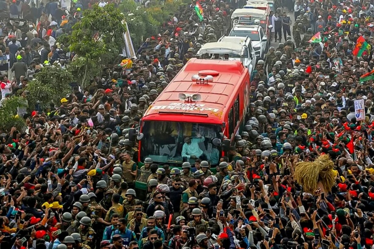Photo prise et diffusée le 25 décembre 2025 par la cellule médias du Parti nationaliste du Bangladesh (BNP) sur sa page Facebook officielle, montrant le président par intérim du BNP, Tarique Rahman (c), saluant ses partisans depuis un bus à son arrivée à Dacca, au Bangladesh