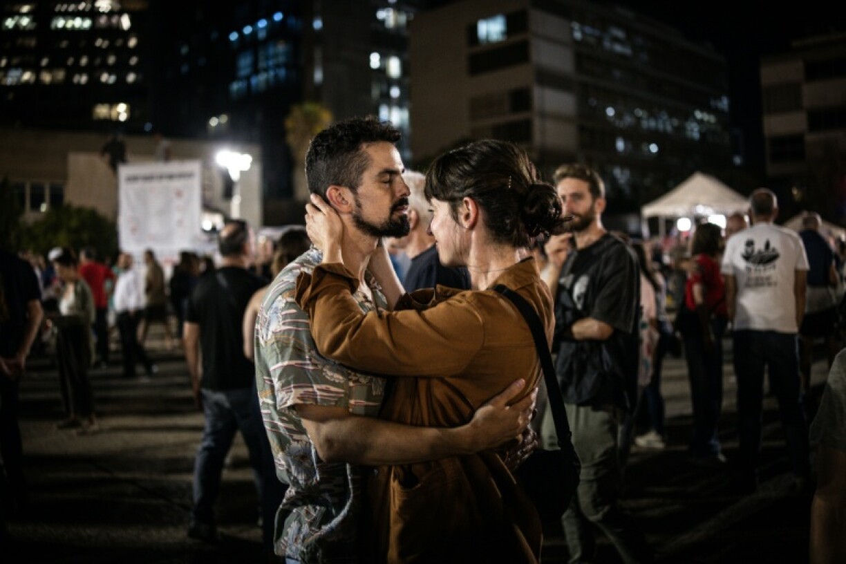 A couple embraces at Hostage Square in Tel Aviv on October 9, 2025, during a gathering following the announcement of the new Gaza ceasefire deal