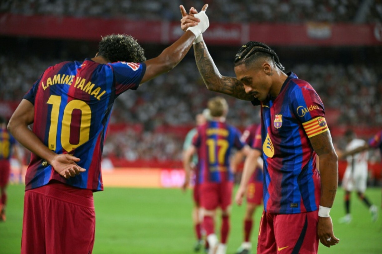 Le Brésilien de Barcelone Raphinha (à droite) célèbre un but avec son coéquipier Lamine Yamal, samedi contre Séville en championnat d'Espagne au stade Ramon Sanchez Pizjuan de Séville.