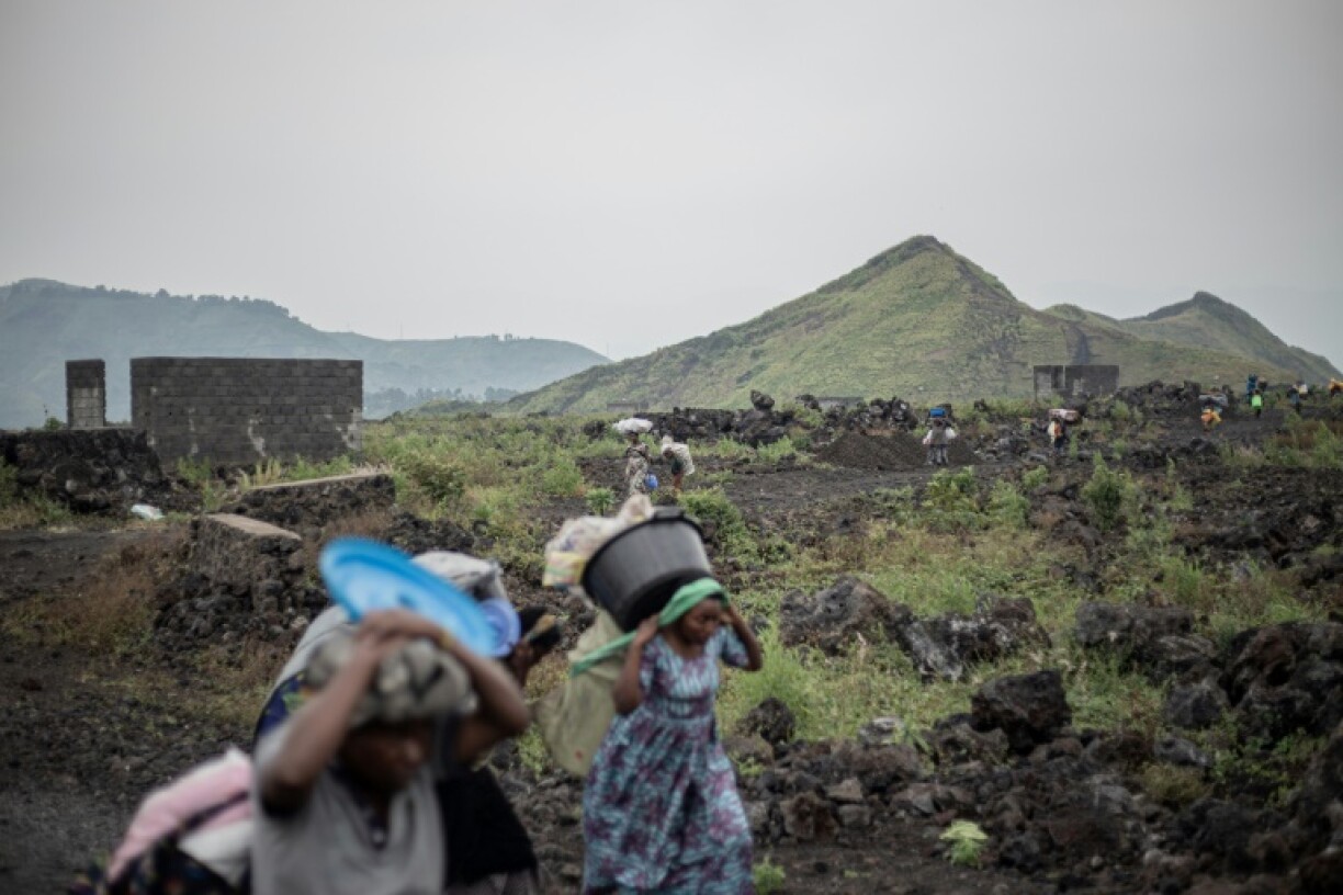 Displaced people drag their possessions with them as they flee advancing M23 fighters in eastern DR Congo