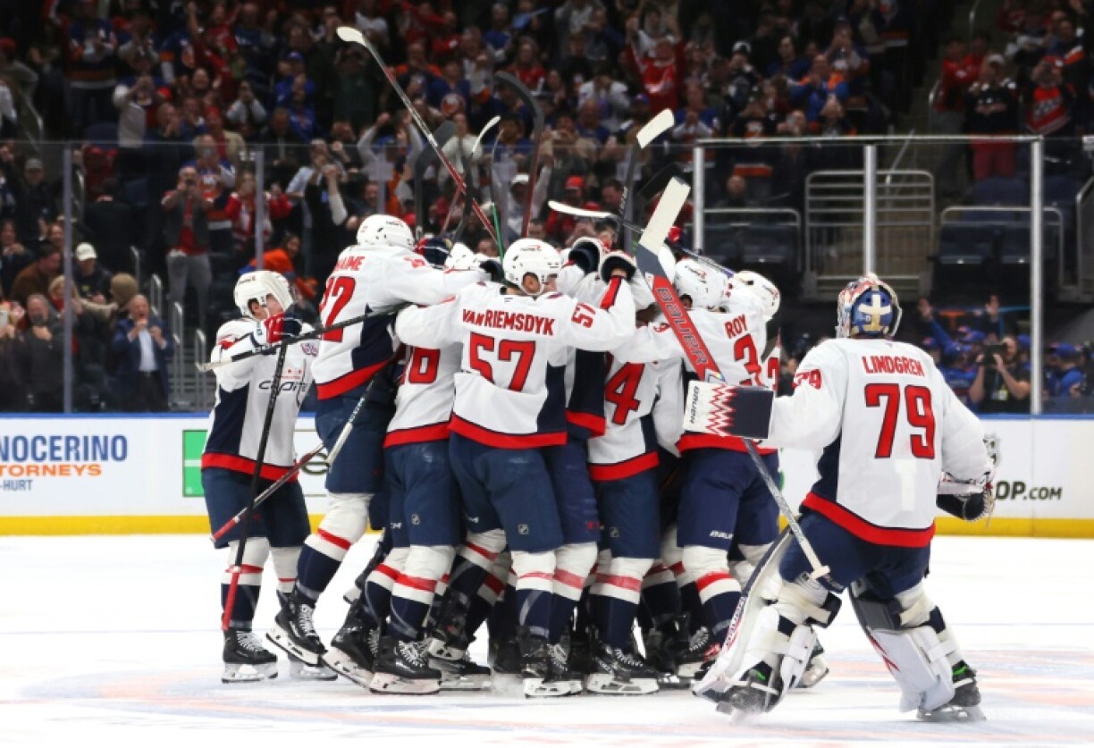 Alex Ovechkin is mobbed by team-mates after scoring his history-making 895th career goal, a new NHL record