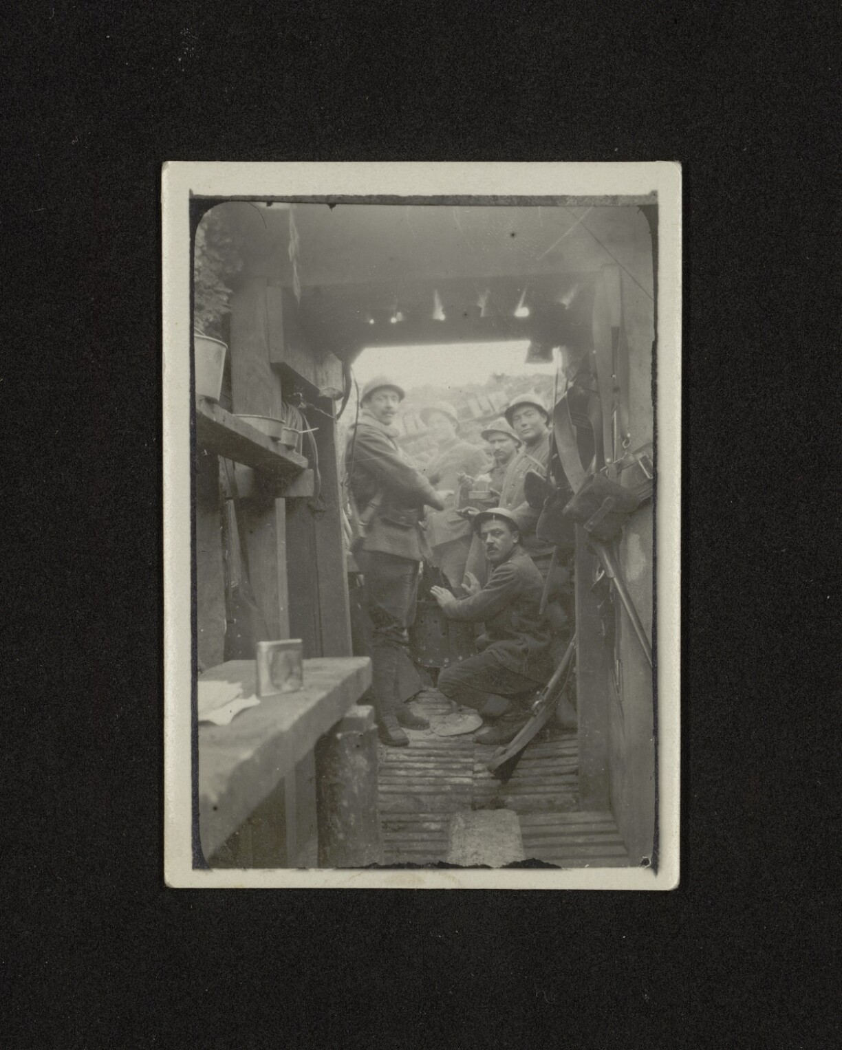 Michel Schmit dans les tranchées avec ses camarades en hiver 1917. On le voit ici accroupi, en train de se réchauffer les mains.