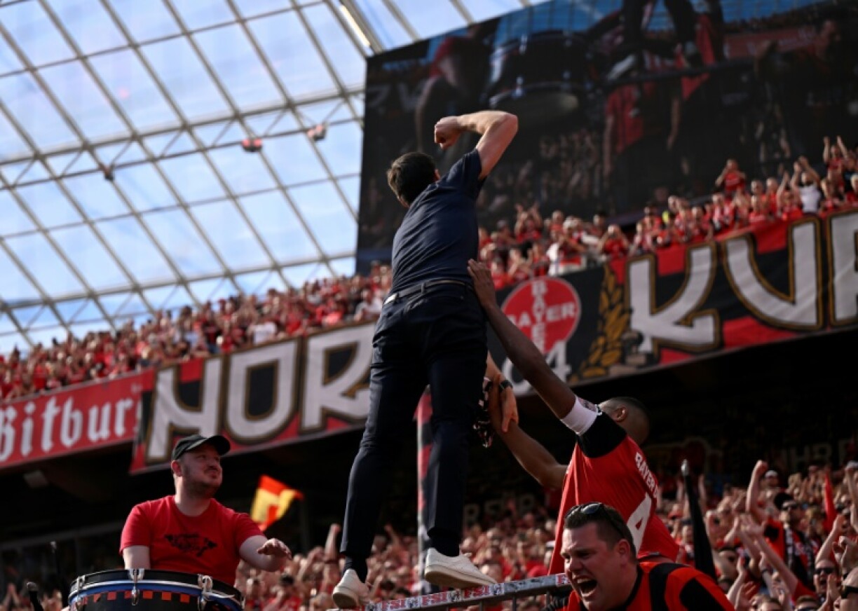 Bayer Leverkusen's outgoing coach Xabi Alonso celebrates with supporters on Sunday