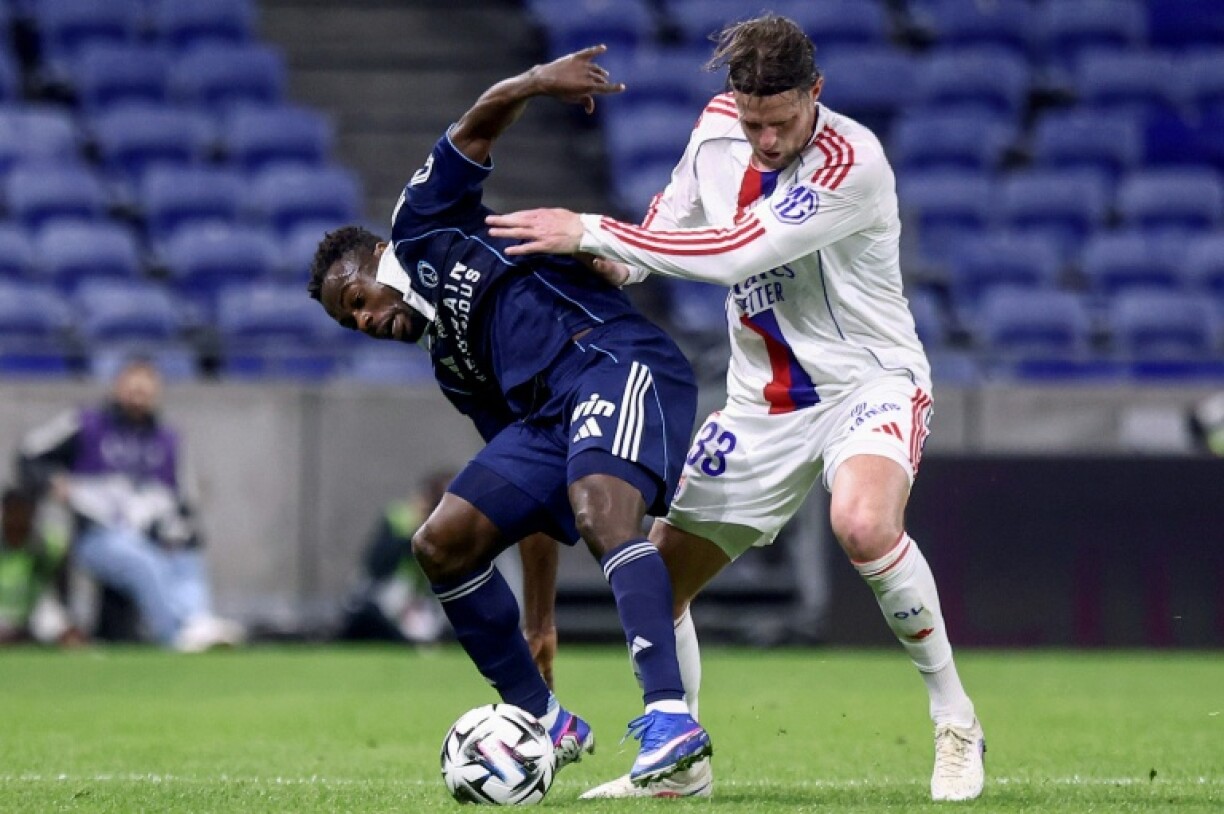 L'attaquant du Paris FC Moses Simon (G) aux prises avec le défenseur de Lyon Hans Hateboer lors du match nul 1-1, le 8 mars 2026 au Groupama Stadium de Decines-Charpieu