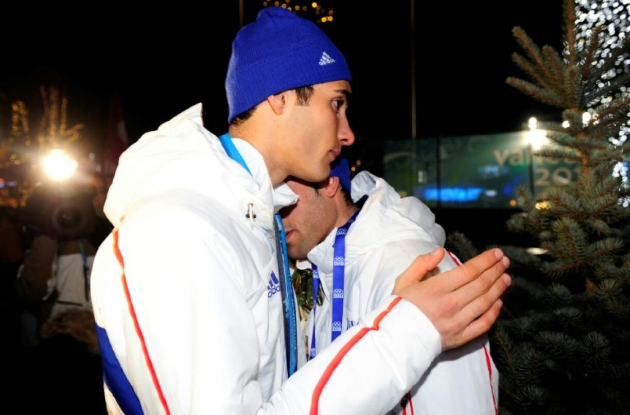 Le médaillé d'argent français Martin Fourcade (à gauche) réconforte son frère Simon après la cérémonie de remise des médailles du 15 km mass start du biathlon masculin pendant les Jeux olympiques d'hiver de Vancouver, le 21 février 2010